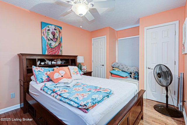 bedroom featuring a ceiling fan, baseboards, and wood finished floors