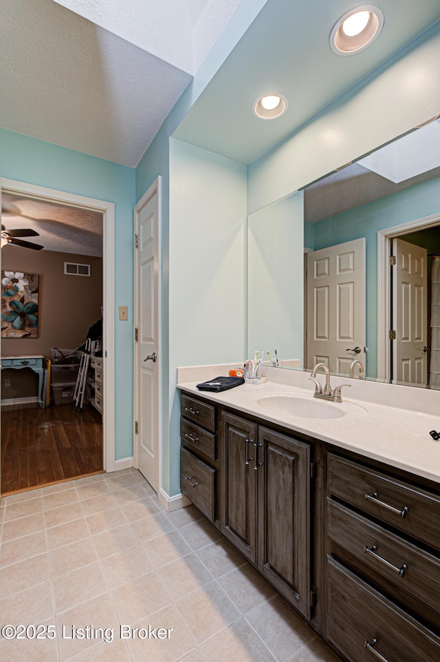 bathroom featuring ceiling fan, tile patterned flooring, vanity, visible vents, and baseboards
