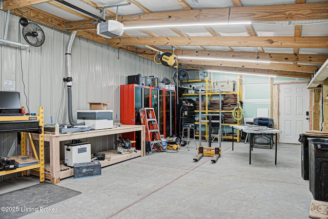 garage featuring a workshop area, metal wall, and a garage door opener
