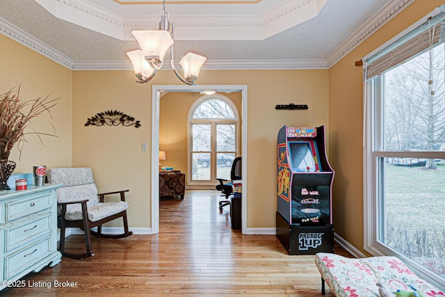 sitting room featuring a chandelier, a textured ceiling, baseboards, and wood finished floors