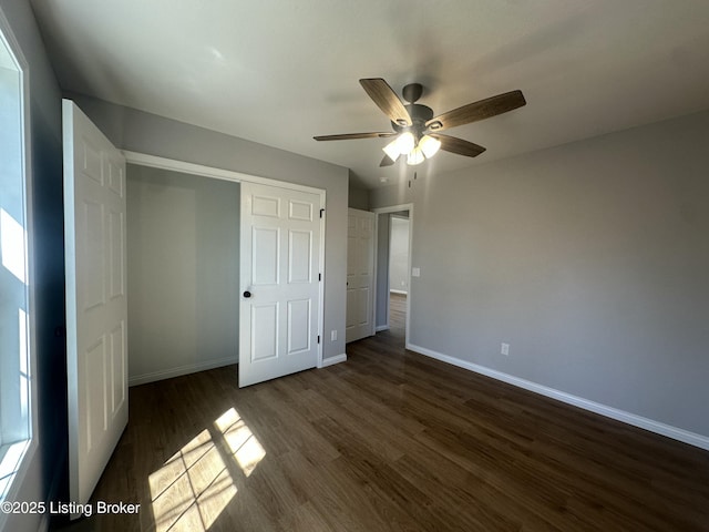 unfurnished bedroom featuring a closet, ceiling fan, baseboards, and dark wood-style flooring