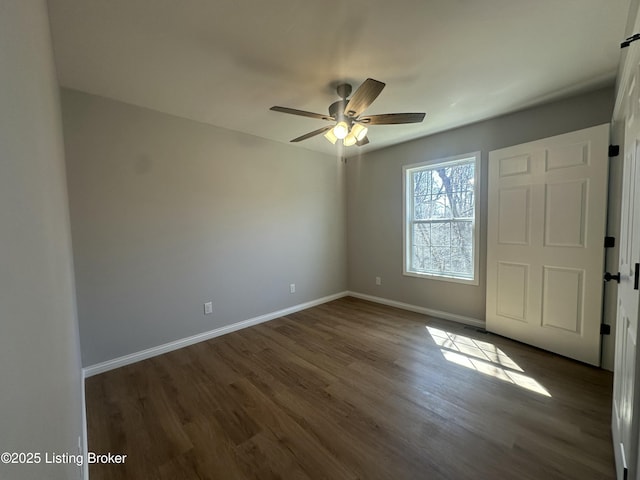 interior space with baseboards, dark wood-type flooring, and a ceiling fan