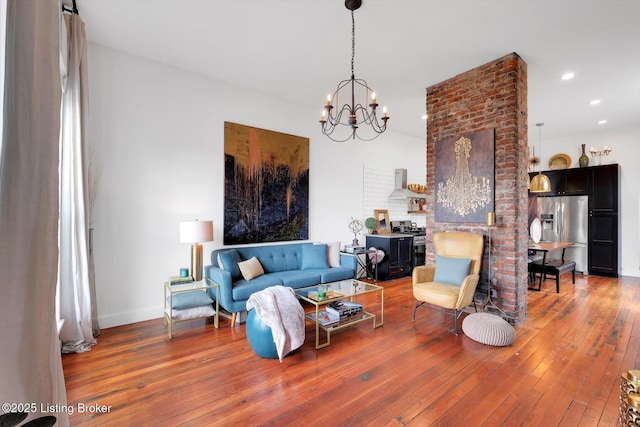 living room with hardwood / wood-style flooring, baseboards, a notable chandelier, and recessed lighting