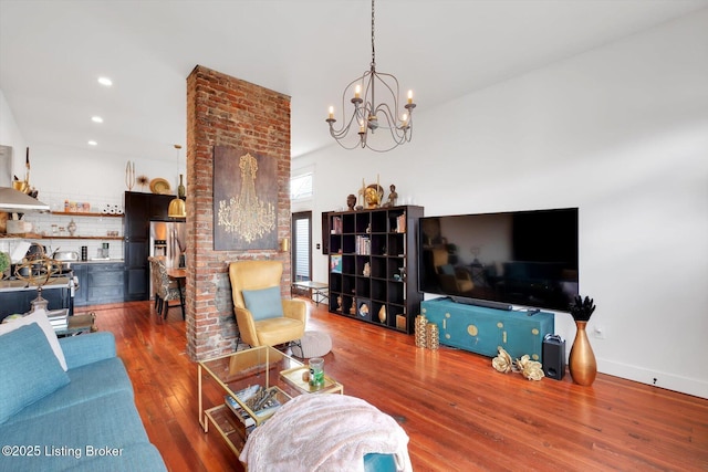 living area featuring recessed lighting, a notable chandelier, baseboards, and hardwood / wood-style flooring