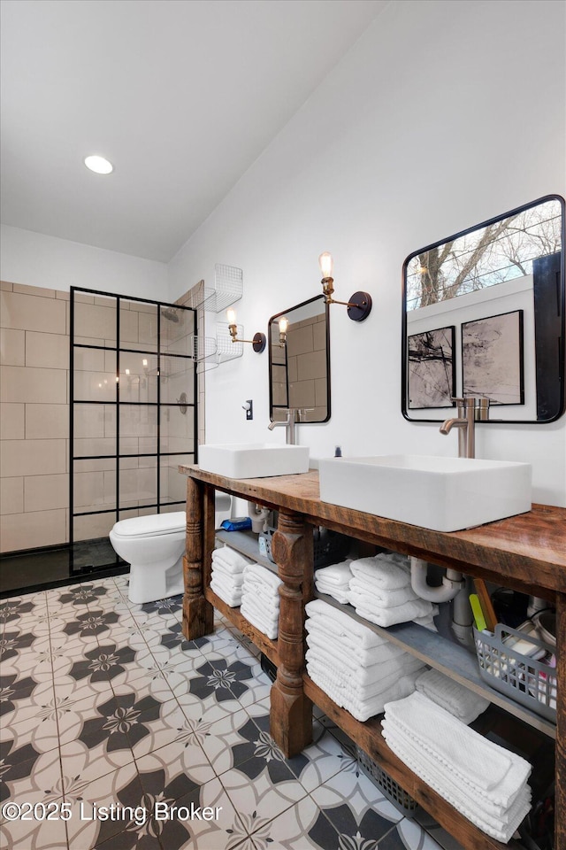 full bath featuring double vanity, walk in shower, a sink, and toilet