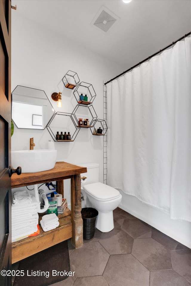 full bath featuring toilet, visible vents, shower / tub combo with curtain, and vanity