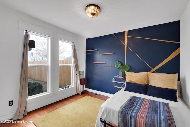 bedroom featuring baseboards and wood finished floors