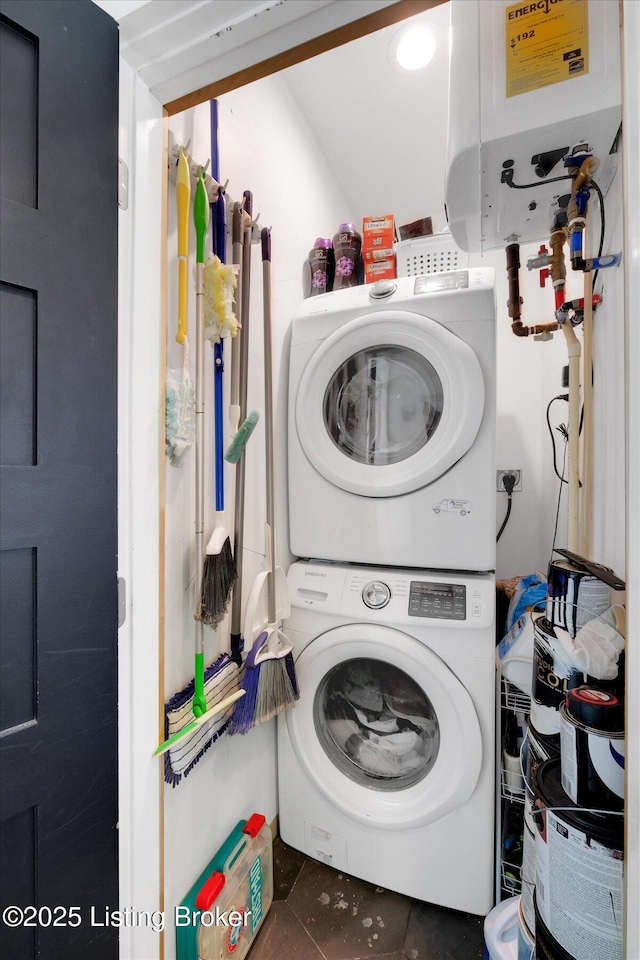 laundry area with water heater, laundry area, tile patterned floors, and stacked washer / drying machine