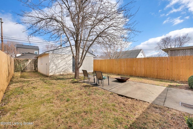 view of yard featuring a patio area, a fenced backyard, and an outdoor structure