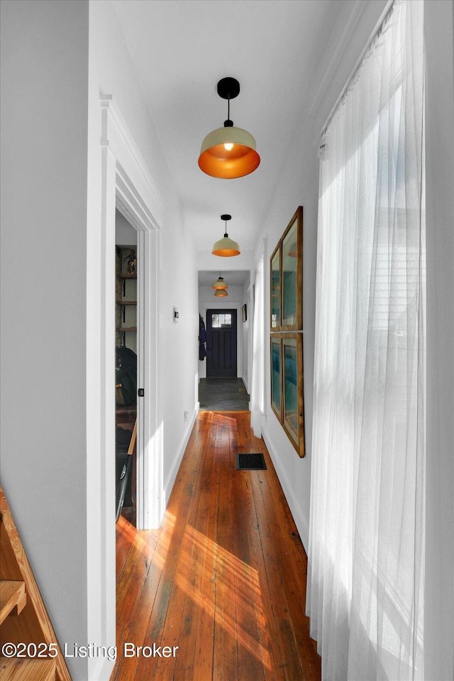 hall with baseboards and hardwood / wood-style floors