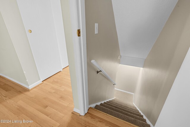 stairs featuring wood finished floors and baseboards