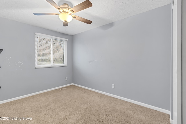 carpeted empty room featuring a textured ceiling, a ceiling fan, and baseboards