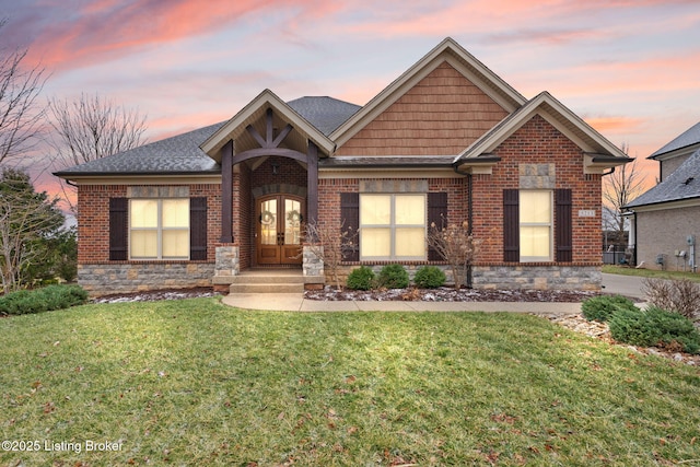 view of front of property featuring french doors, a front lawn, and brick siding