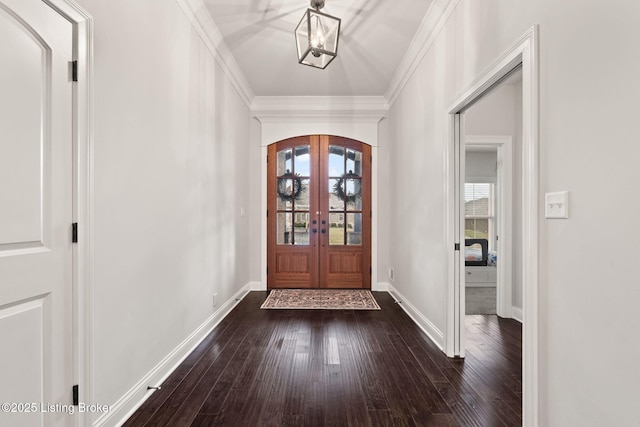 entrance foyer with dark wood-style floors, arched walkways, french doors, ornamental molding, and baseboards