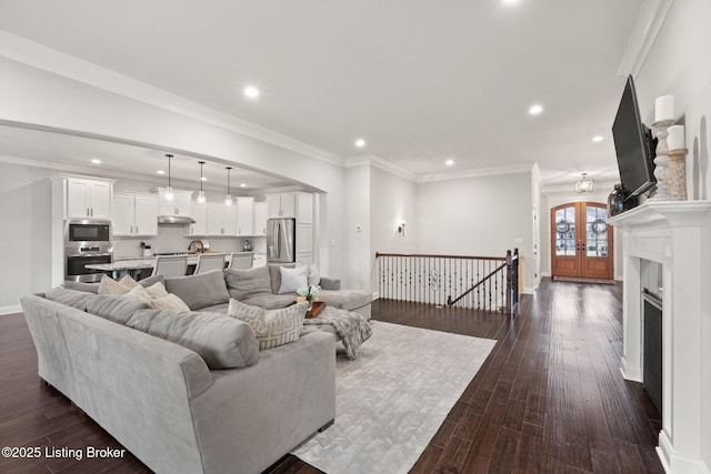 living area with dark wood-style floors, french doors, recessed lighting, ornamental molding, and baseboards