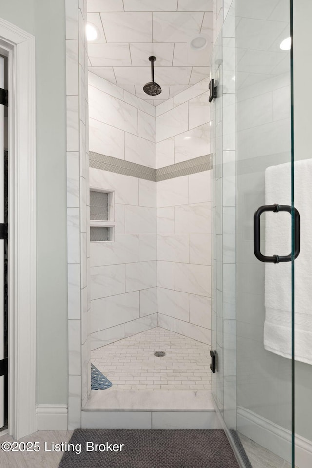 bathroom with a stall shower and baseboards