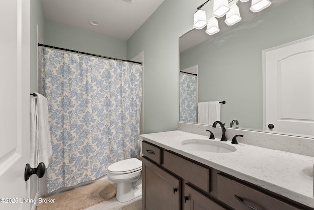 bathroom with a shower with shower curtain, vanity, and toilet