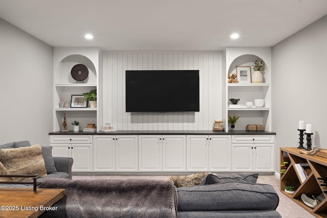 carpeted living area featuring built in shelves and recessed lighting