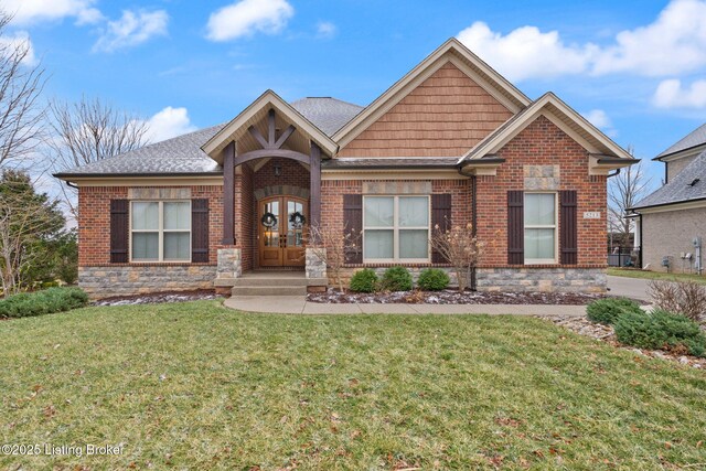 craftsman inspired home with brick siding, a front lawn, and french doors