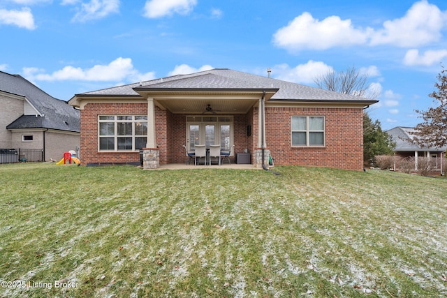 back of property with a yard, a patio, brick siding, and a ceiling fan