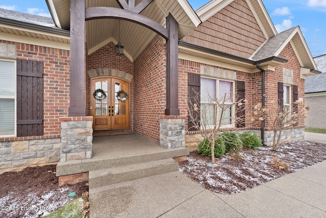 view of exterior entry with brick siding and french doors