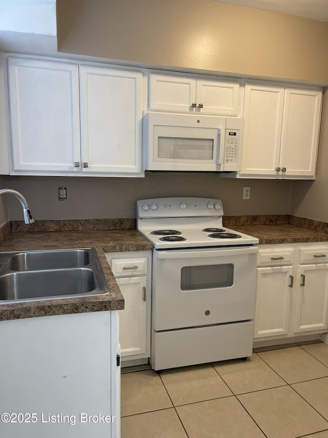 kitchen with a sink, white appliances, white cabinets, and light tile patterned floors