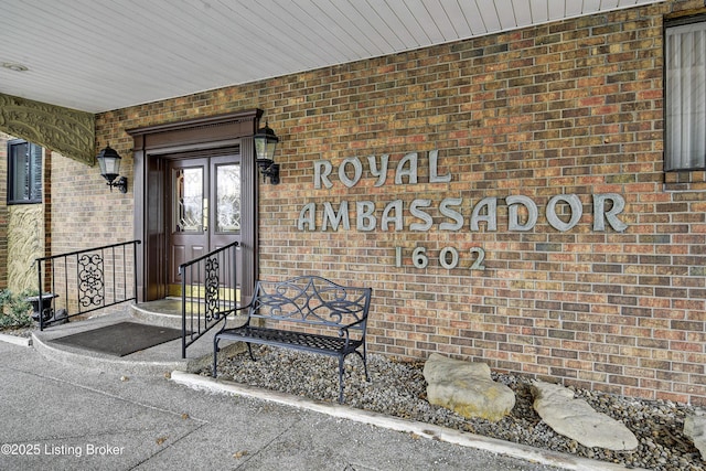 view of exterior entry featuring brick siding