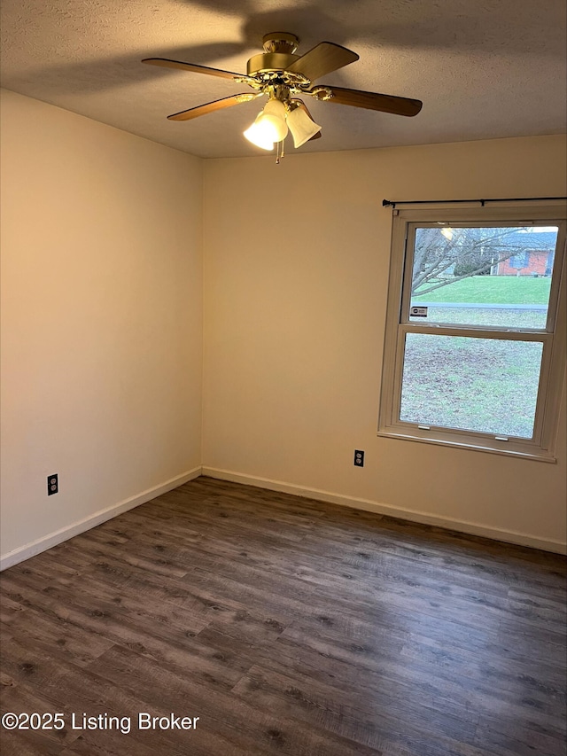 empty room with ceiling fan, baseboards, dark wood-style flooring, and a textured ceiling