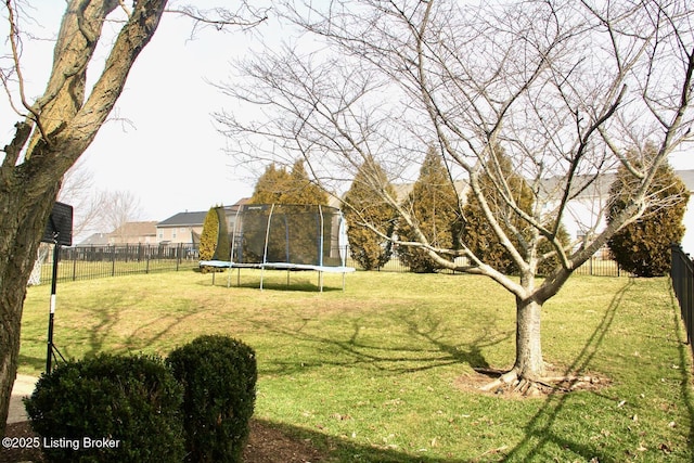 view of yard featuring a trampoline and fence