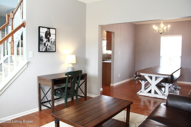 living room featuring stairs, baseboards, an inviting chandelier, and wood finished floors