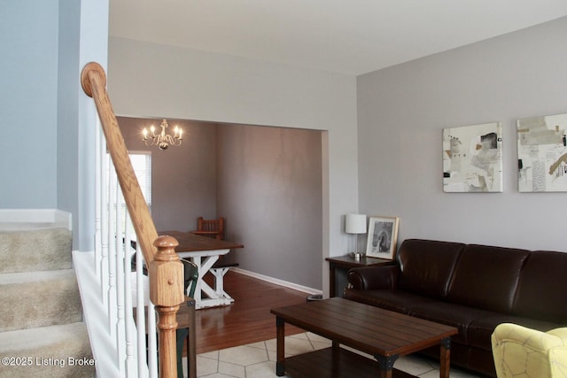 living area with light wood finished floors, stairs, baseboards, and a notable chandelier