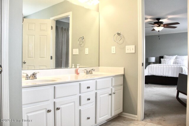 ensuite bathroom featuring a ceiling fan, tile patterned flooring, a sink, and double vanity