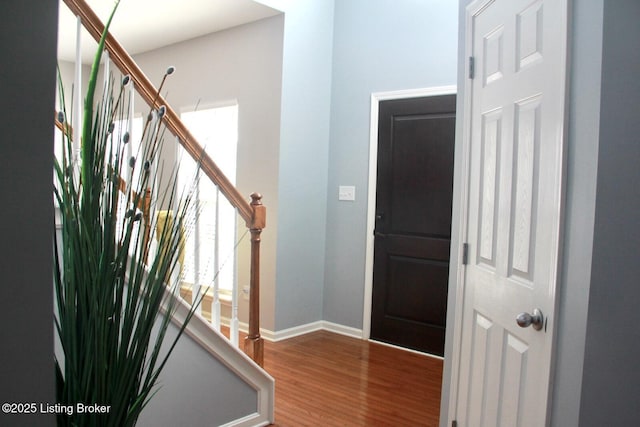 foyer featuring stairs, baseboards, and wood finished floors