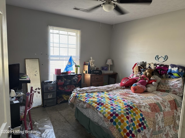 bedroom featuring a ceiling fan, visible vents, and a textured ceiling