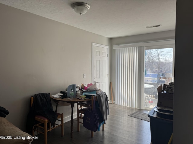 dining space featuring visible vents, a textured ceiling, and wood finished floors