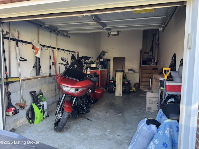 garage featuring a garage door opener and concrete block wall