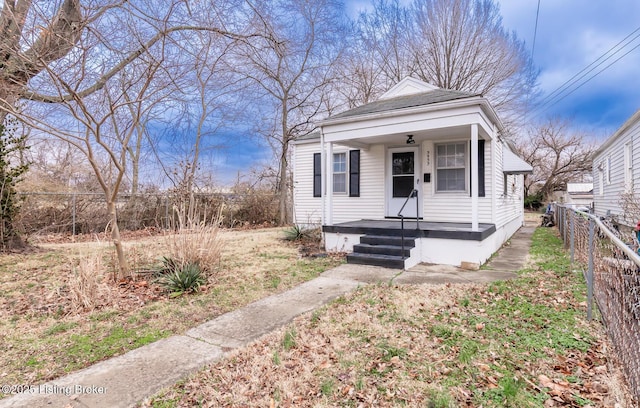 shotgun-style home featuring a porch and fence