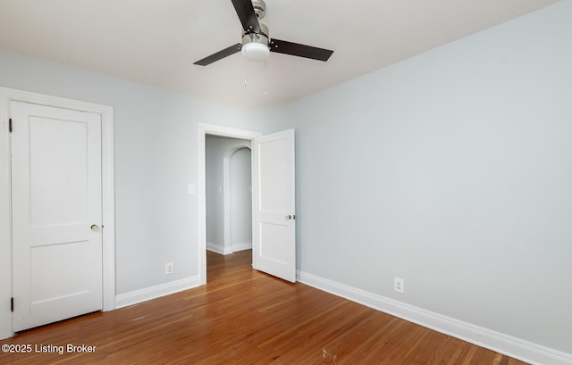 unfurnished bedroom with wood finished floors, baseboards, and ceiling fan