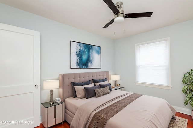 bedroom featuring wood finished floors, baseboards, and ceiling fan