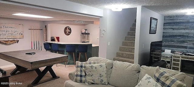 bar featuring a dry bar, stairs, a textured ceiling, carpet flooring, and wood walls