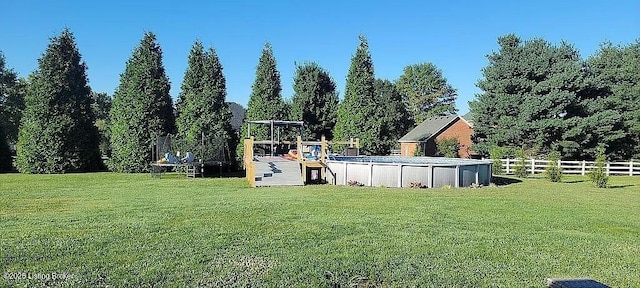 view of yard featuring an outdoor pool and fence