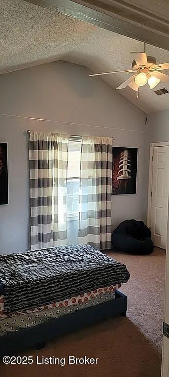 carpeted bedroom featuring a ceiling fan, visible vents, vaulted ceiling, and a textured ceiling