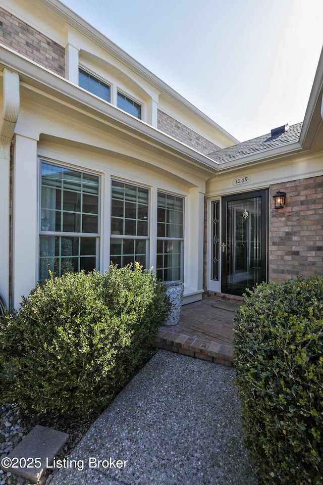 doorway to property with brick siding