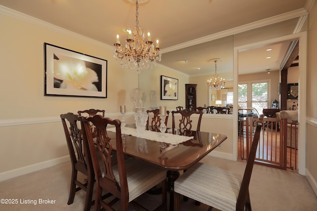 carpeted dining room featuring a notable chandelier, baseboards, and ornamental molding