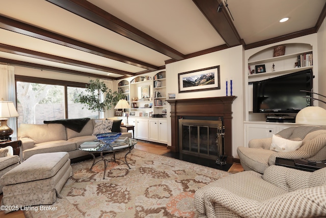 living area with beamed ceiling, wood finished floors, a fireplace with flush hearth, and built in features