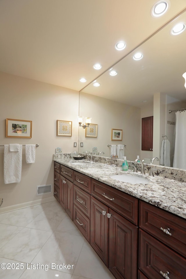 bathroom featuring double vanity, visible vents, recessed lighting, and a sink