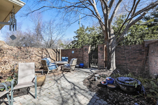 view of patio with an outdoor fire pit, a fenced backyard, and a gate