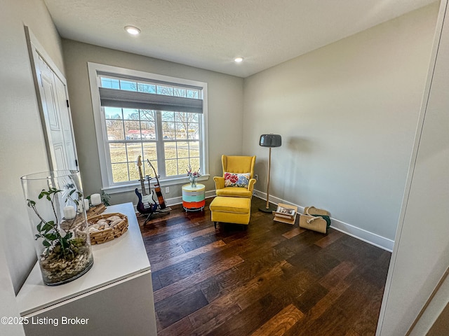 living area with recessed lighting, a textured ceiling, baseboards, and wood finished floors