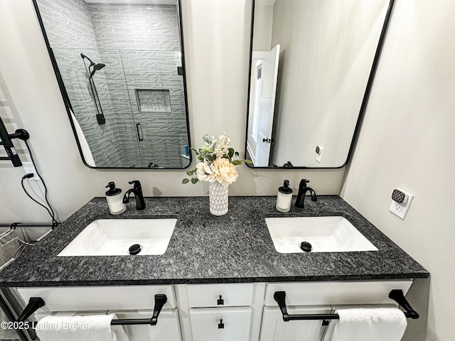 full bathroom featuring double vanity, a sink, and a shower stall