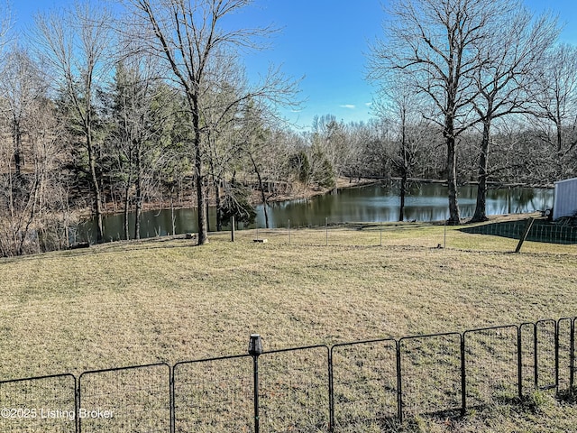 view of yard featuring a water view and fence